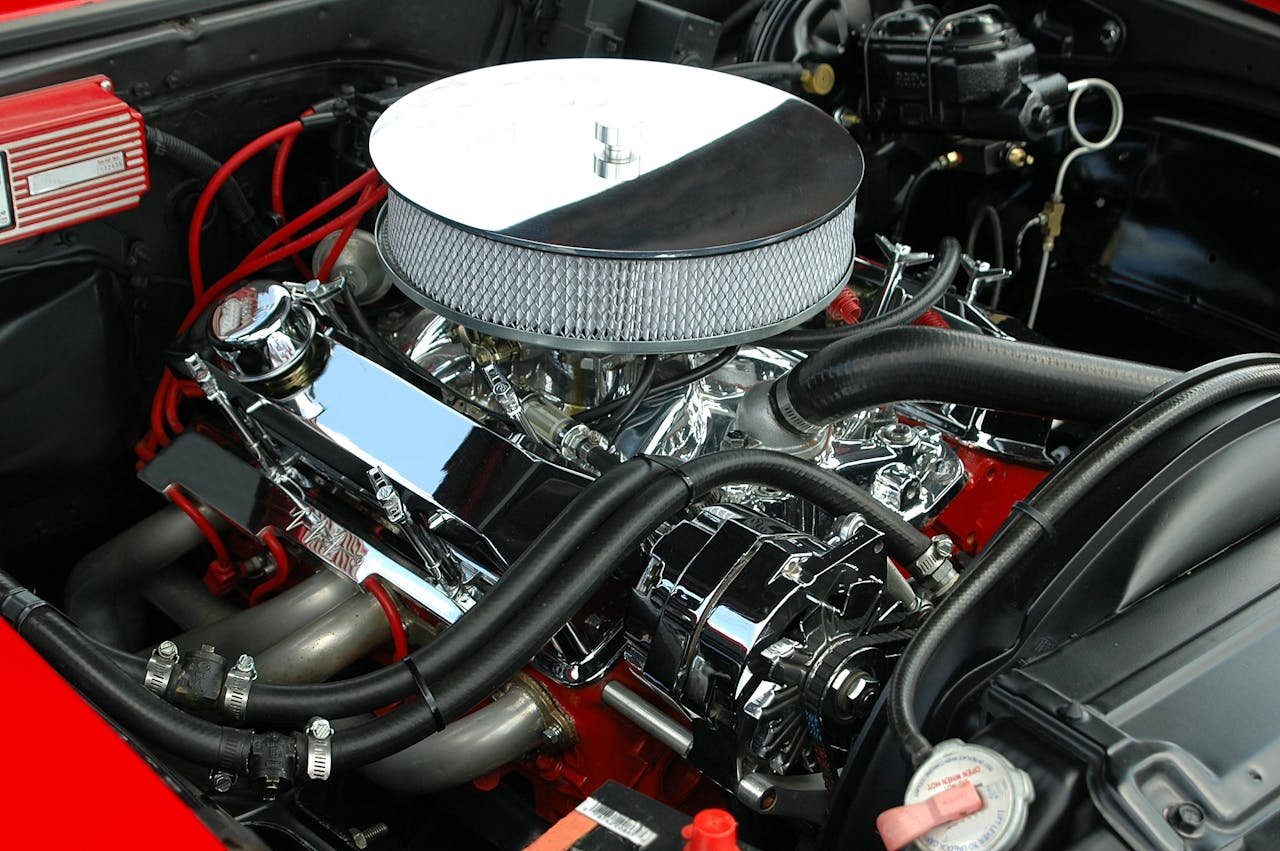 portfolio-05 Detailed view of a polished, high-performance car engine showcasing chrome detailing and intricate mechanics.